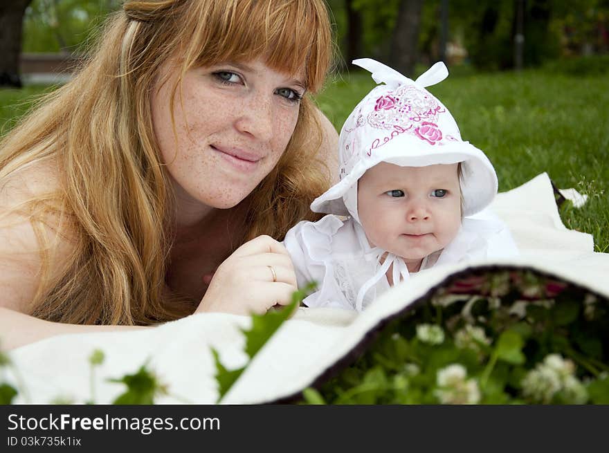 The portrait of the baby and mother on cover in the park. The portrait of the baby and mother on cover in the park