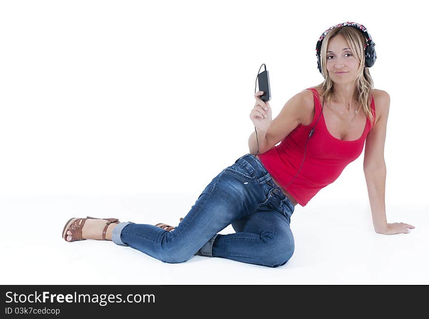 Trendy woman listening to music on her mp3 player wearing headphones. Trendy woman listening to music on her mp3 player wearing headphones