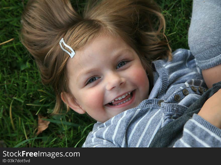 Face of young girl laying on grass. Face of young girl laying on grass