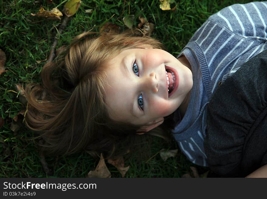 Face of young girl laying on grass. Face of young girl laying on grass