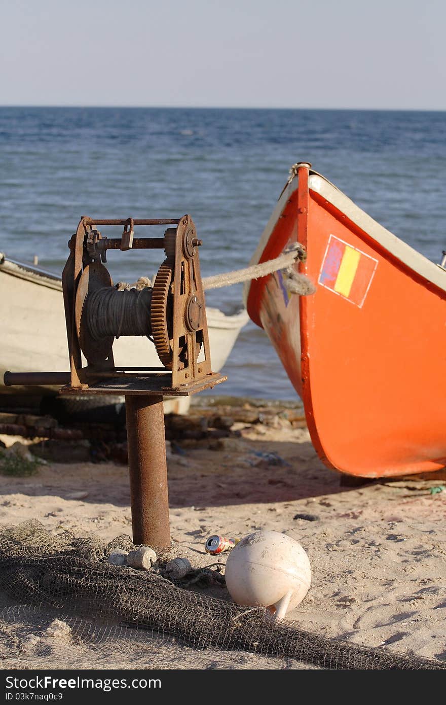 Old crack mechanism pulling small boat out of water. Old crack mechanism pulling small boat out of water