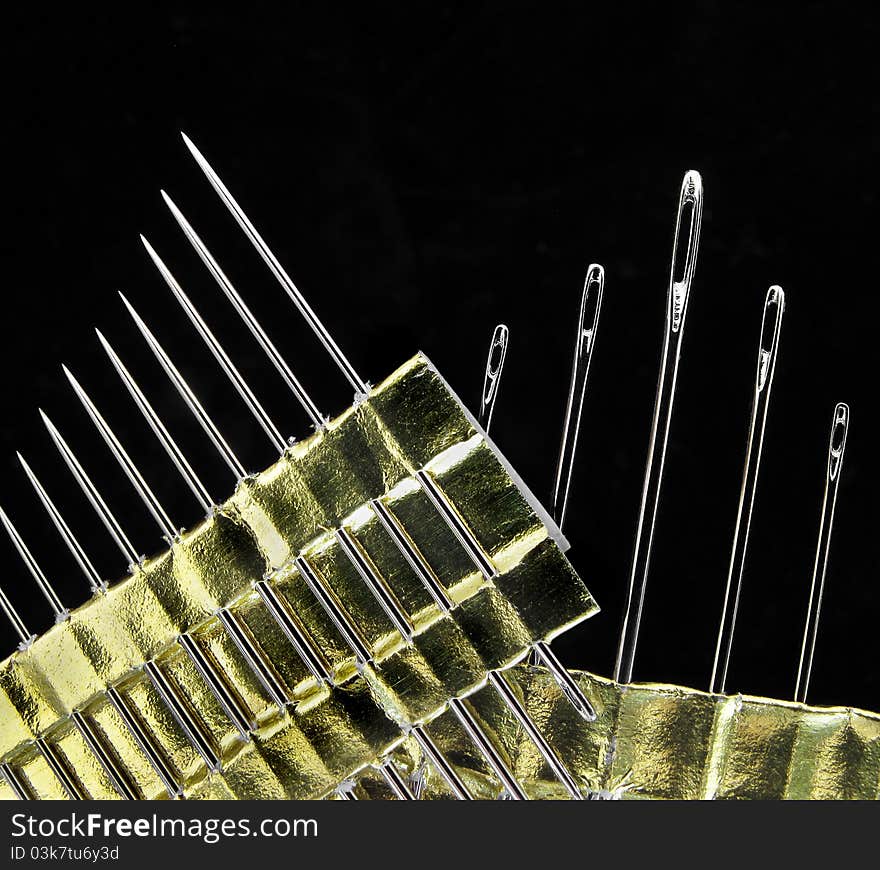 Sewing needles on black background