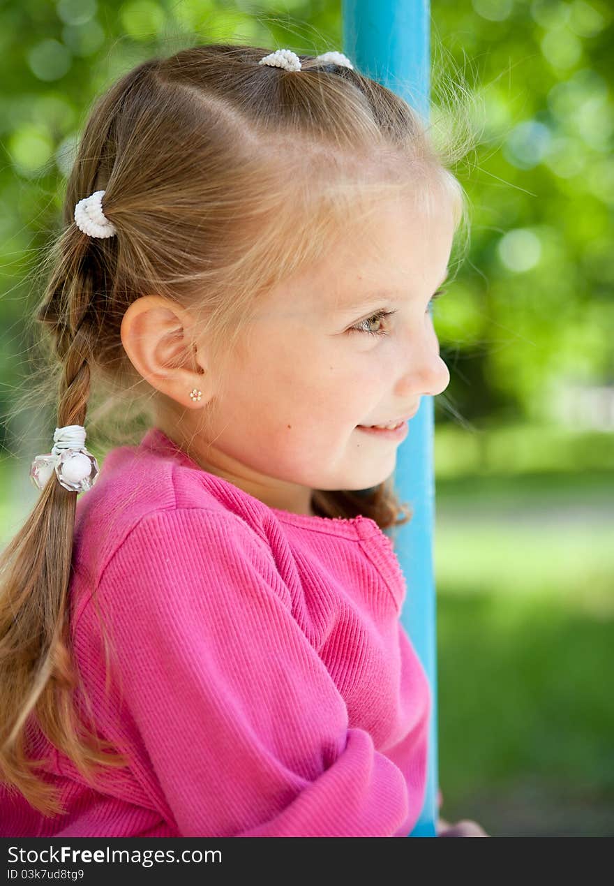 Cute little girl smiling in a park close-up