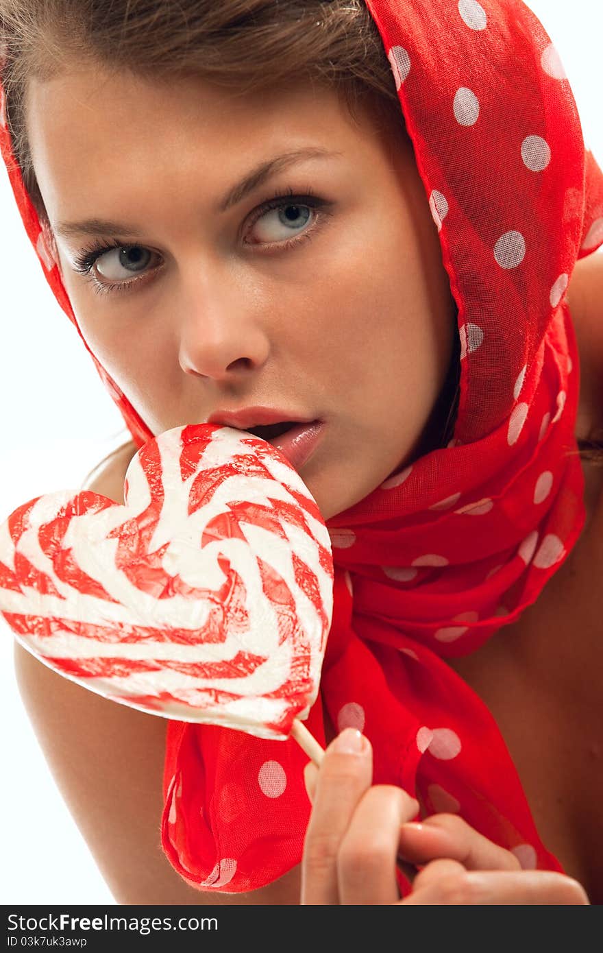 Close-up portrait of young woman with heart shaped lollipop