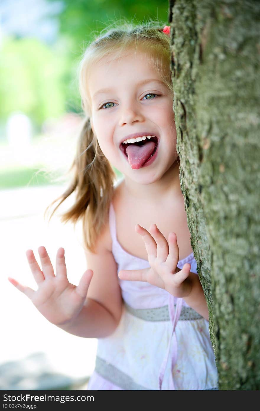 Cute little girl smiling in a park close-up