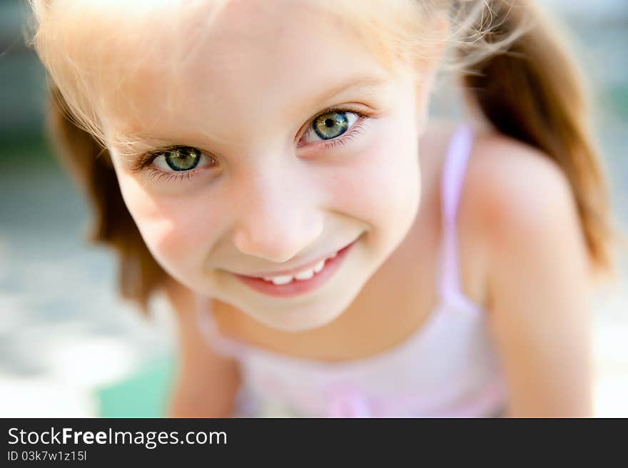 Cute little girl smiling in a park close-up