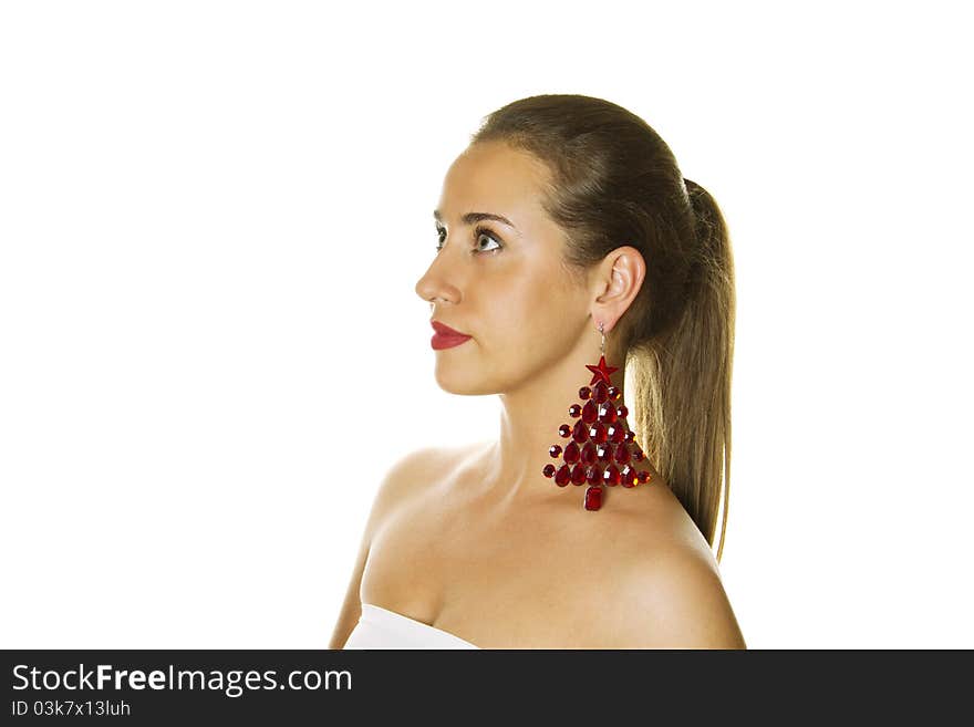 Close-up of a beautiful young woman c big earrings made ??of precious red stones in the shape of a Christmas tree. Isolation. Close-up of a beautiful young woman c big earrings made ??of precious red stones in the shape of a Christmas tree. Isolation