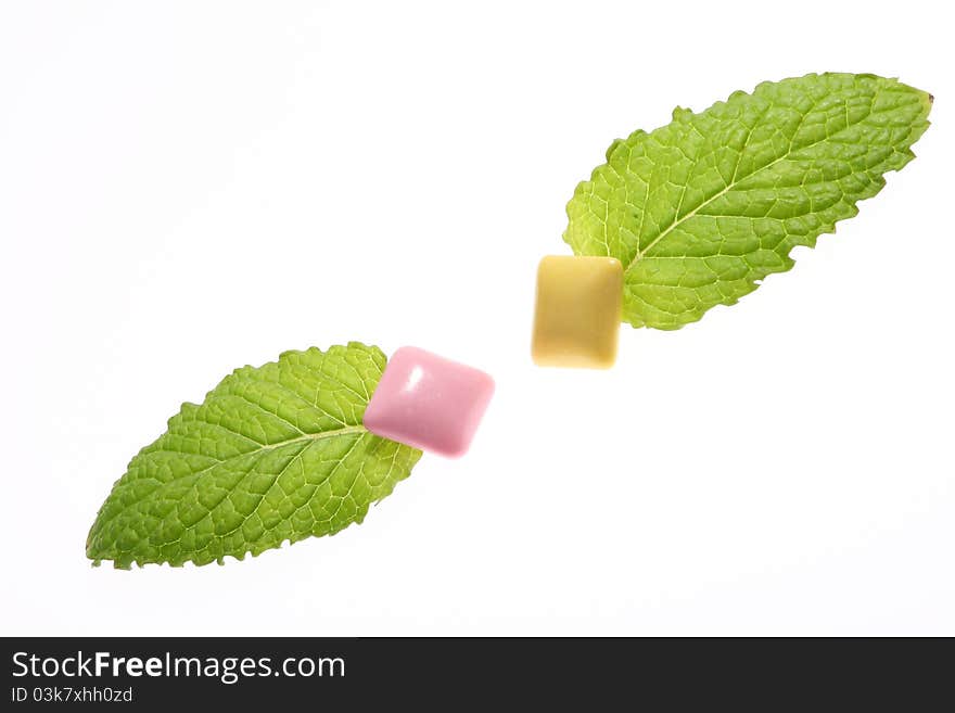 Mint leaf and chewing gum on white background