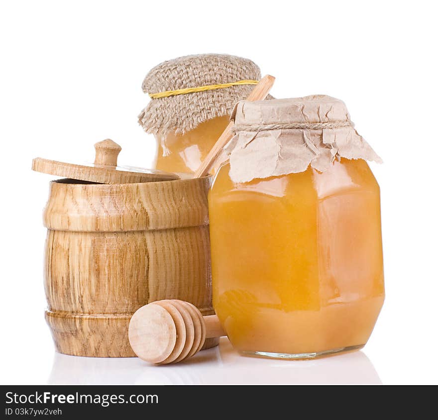 Jars and pot full of honey isolated on white