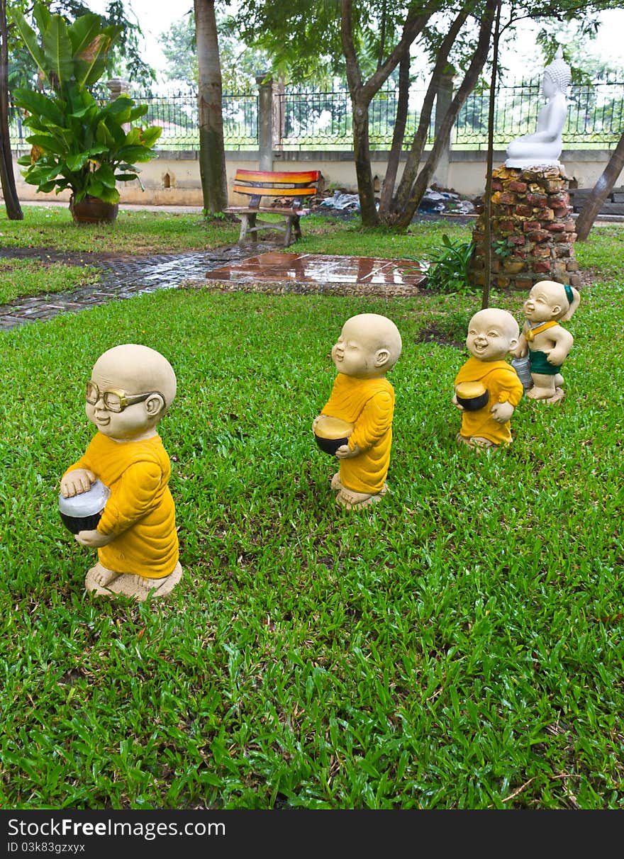 The stucco temple boy with monks was walking on the lawn. The stucco temple boy with monks was walking on the lawn.