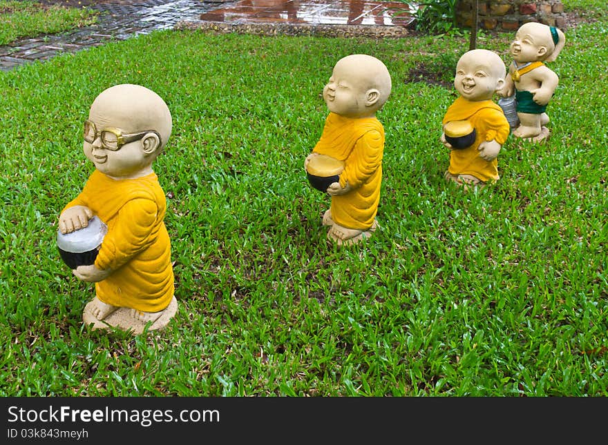 The stucco temple boy with monks was walking on the lawn. The stucco temple boy with monks was walking on the lawn.