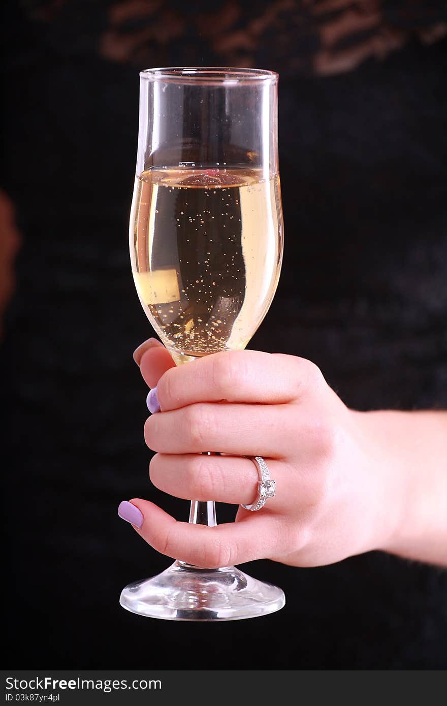 A close up of a ladies hand holding a glass of champagne. A close up of a ladies hand holding a glass of champagne