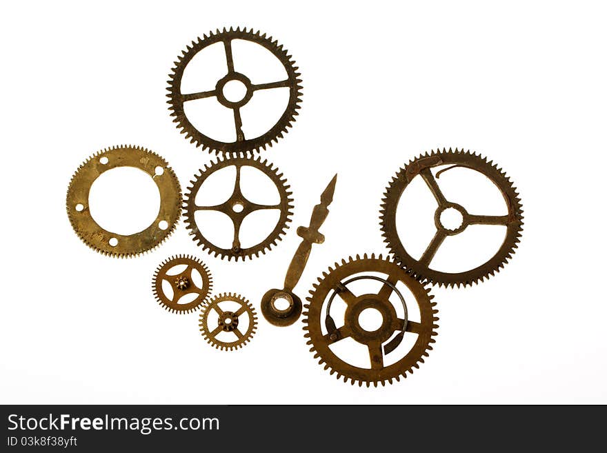 Old clockwork mechanism with brass metal cogs on white background