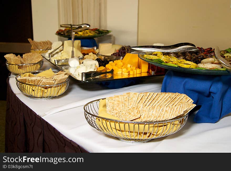 A buffet table is set out with various cheese and cracker selections at event. A buffet table is set out with various cheese and cracker selections at event.