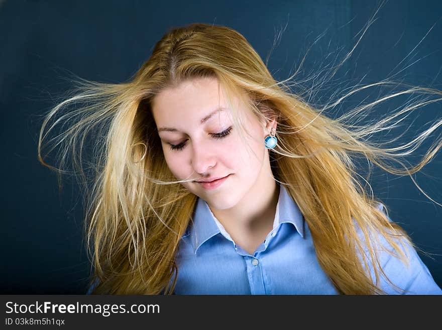 A teenage girl lowered her eyelashes, her long blond hair waving in the wind. A teenage girl lowered her eyelashes, her long blond hair waving in the wind