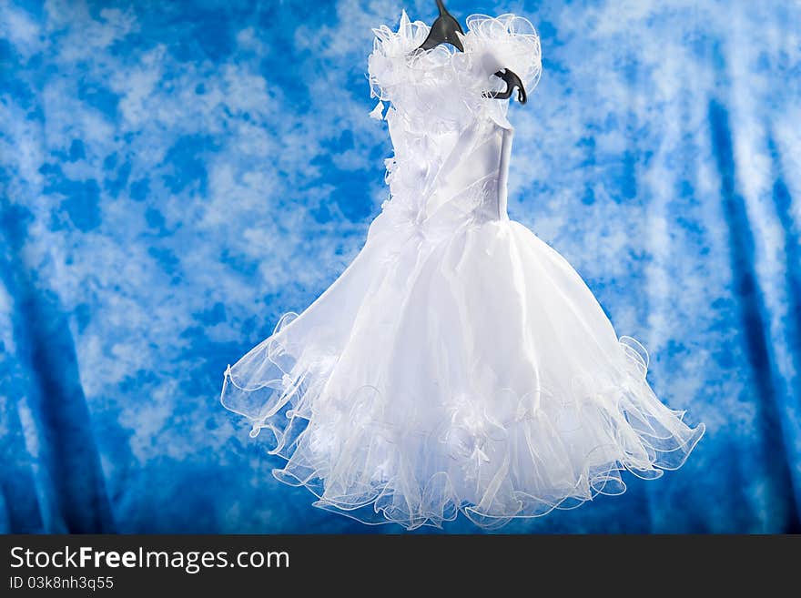 White dress elegant air to a little girl on a blue background. White dress elegant air to a little girl on a blue background