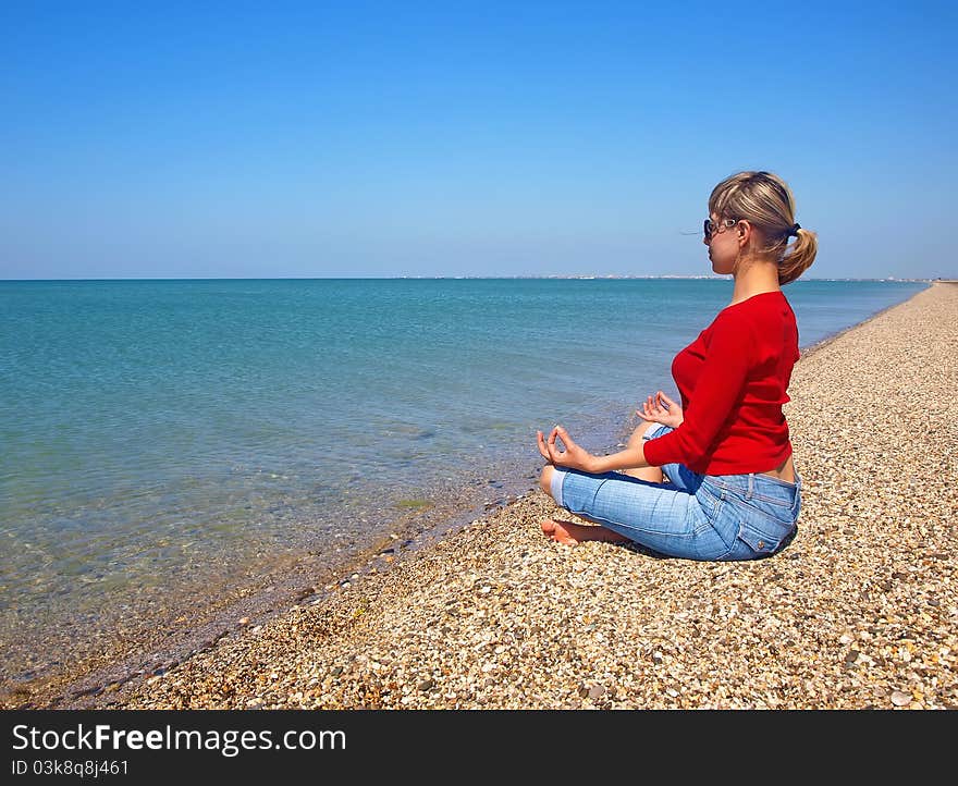 Girl In Yoga Position On An Empty Beach