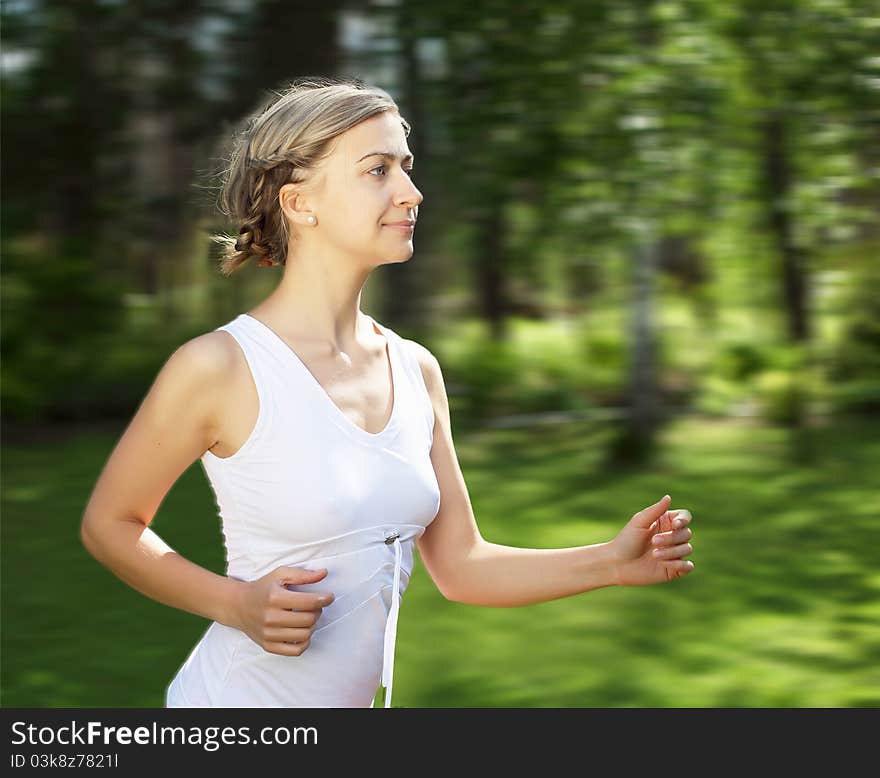 Young girl in a white shirt and red pants likes to run outdoors.