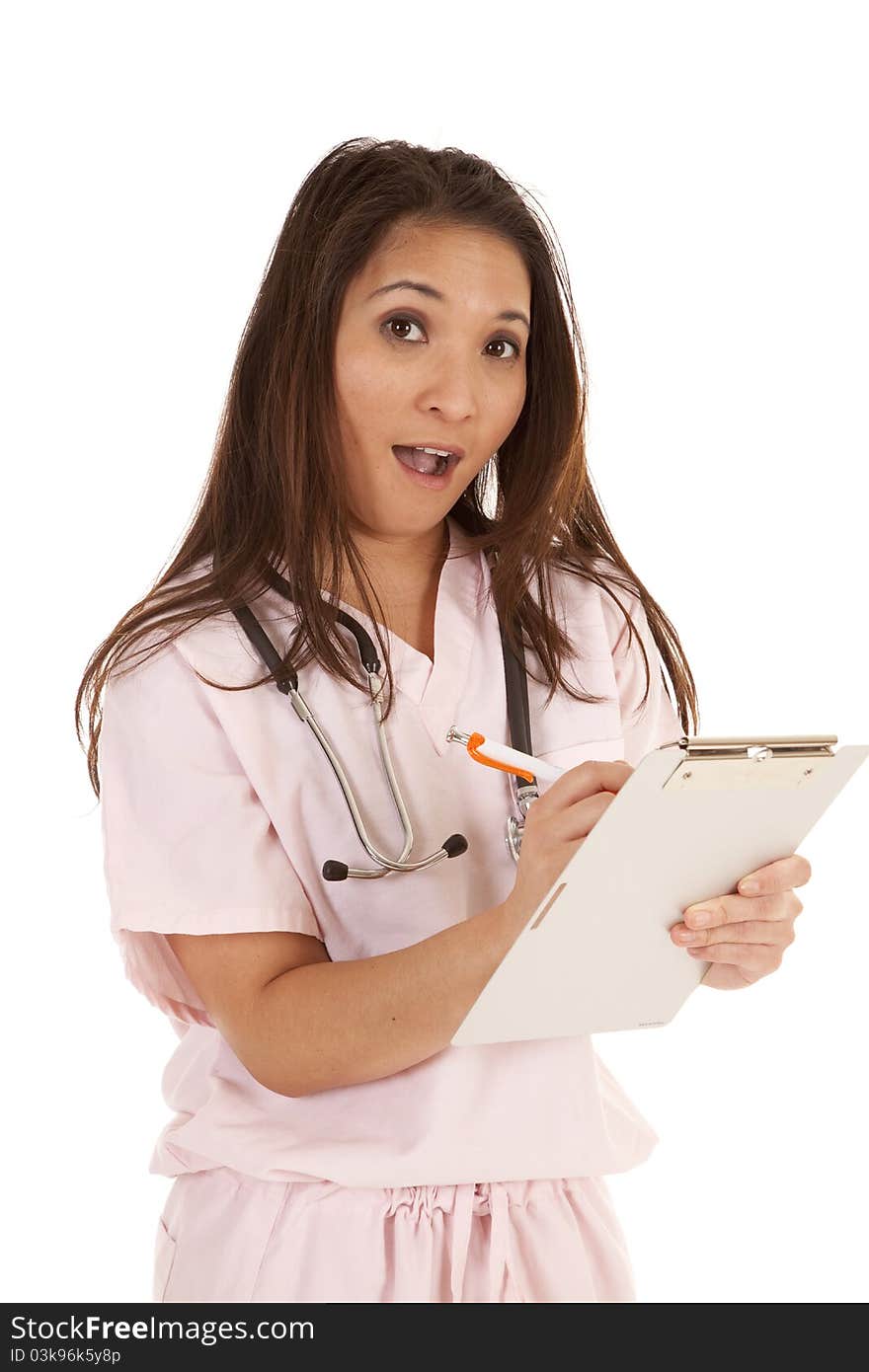 A woman in her scrubs taking shocking notes. A woman in her scrubs taking shocking notes.