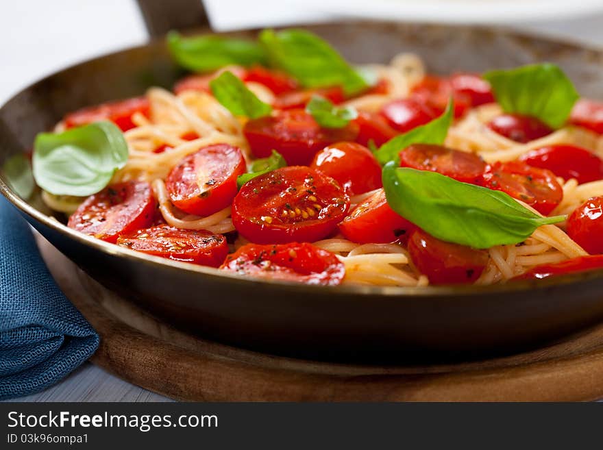 Spaghetti with cherry tomato on a rustic pan