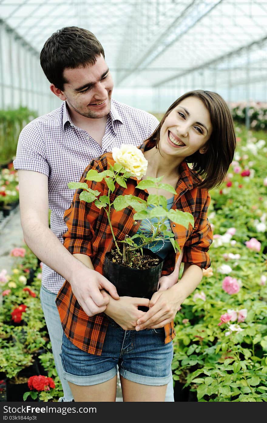 An image of a young couple with a flower pot. An image of a young couple with a flower pot