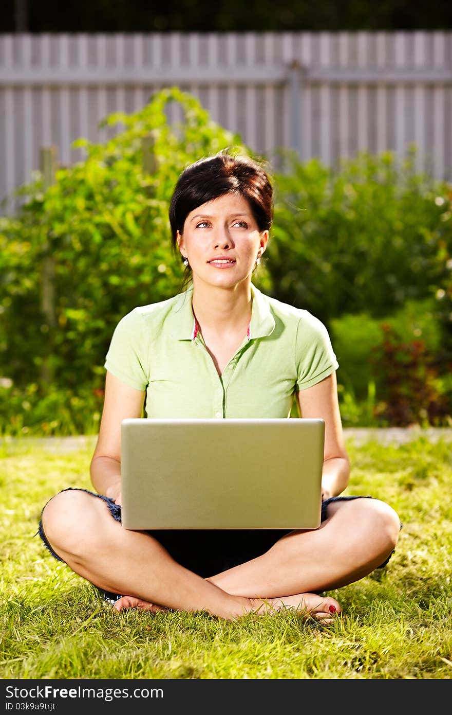 Caucasian woman is lying on the grass with laptop. Caucasian woman is lying on the grass with laptop