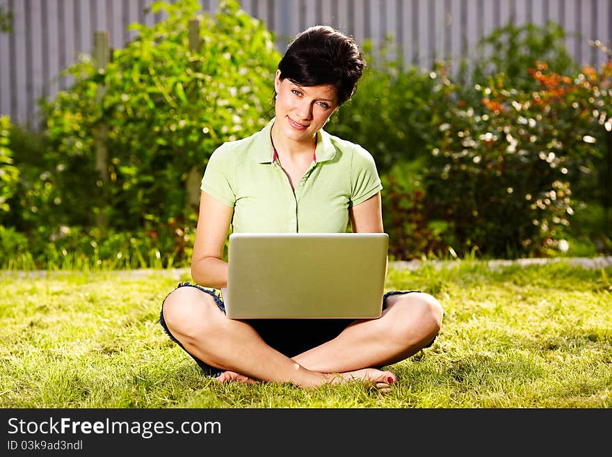 Caucasian woman is lying on the grass with laptop. Caucasian woman is lying on the grass with laptop