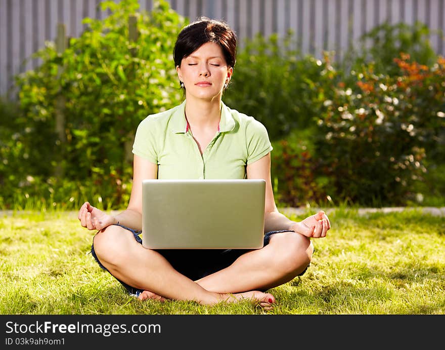 Caucasian woman is relaxing on the grass with laptop. Caucasian woman is relaxing on the grass with laptop