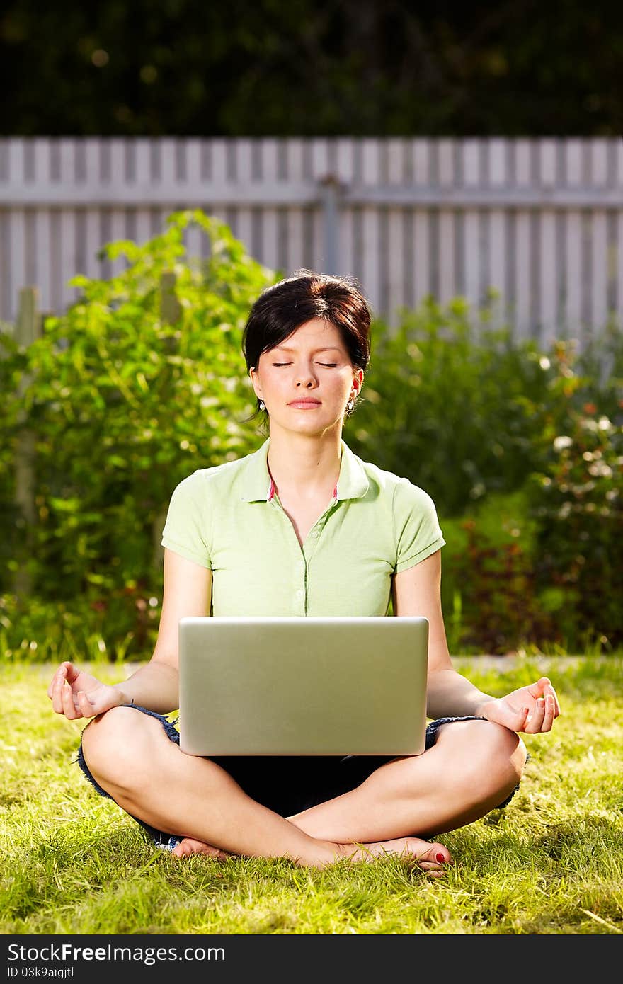 Caucasian woman is relaxing on the grass with laptop. Caucasian woman is relaxing on the grass with laptop