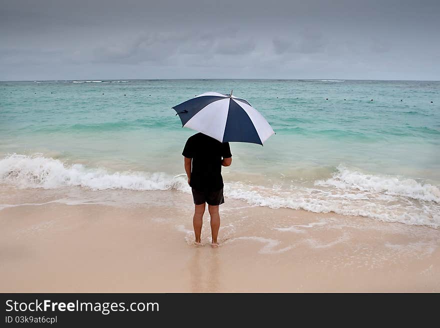 Tanned Man Stand With Umbrella In Blue Sea