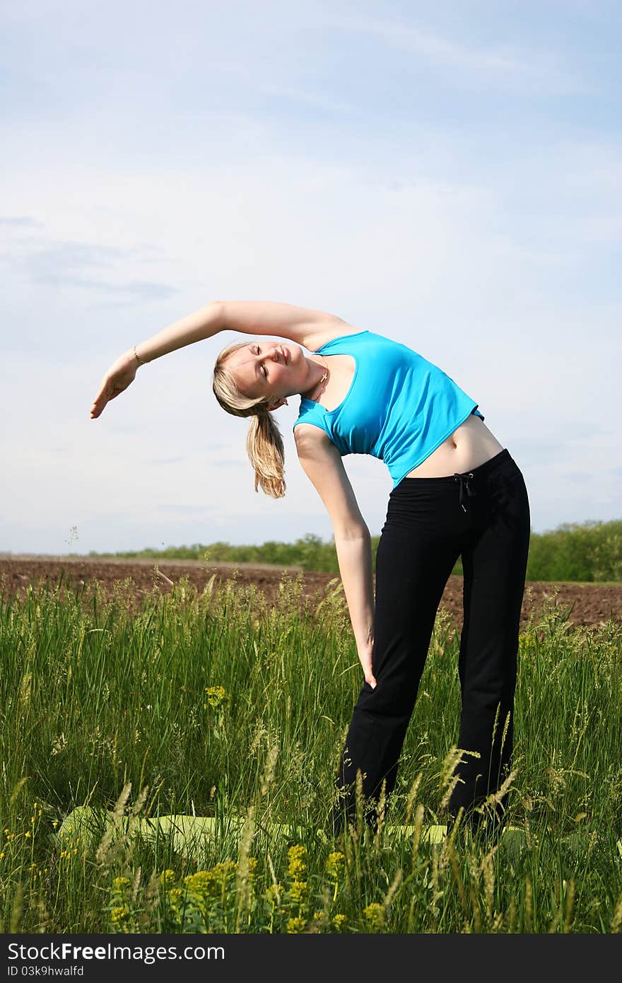 Young woman doing exercises outdoors. Young woman doing exercises outdoors