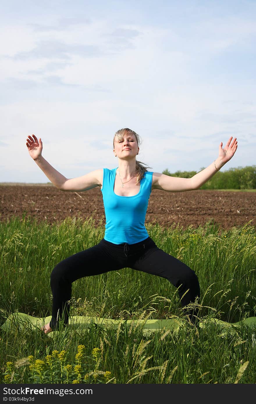 Young woman doing yoga exercises outdoors. Young woman doing yoga exercises outdoors