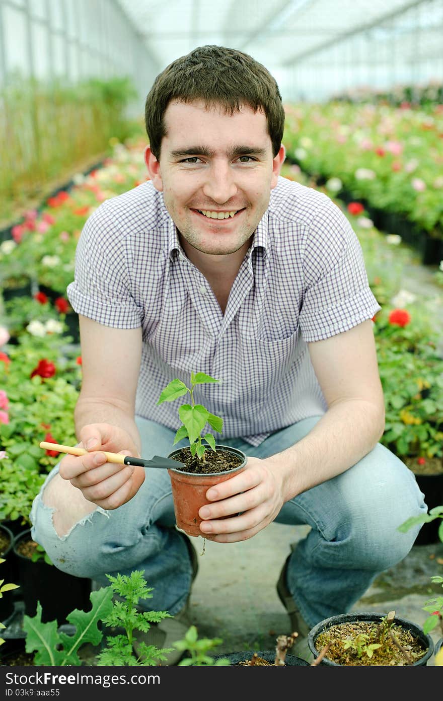 An image of a man with a plant in a pot. An image of a man with a plant in a pot