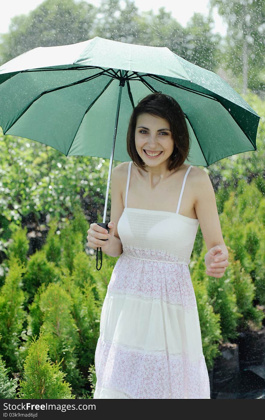 An image of a young girl with a green umbrella. An image of a young girl with a green umbrella