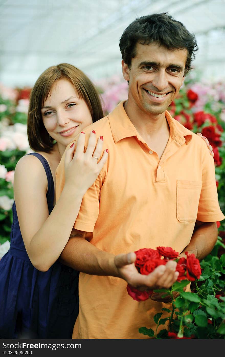 An image of a young couple in a greenhouse. An image of a young couple in a greenhouse