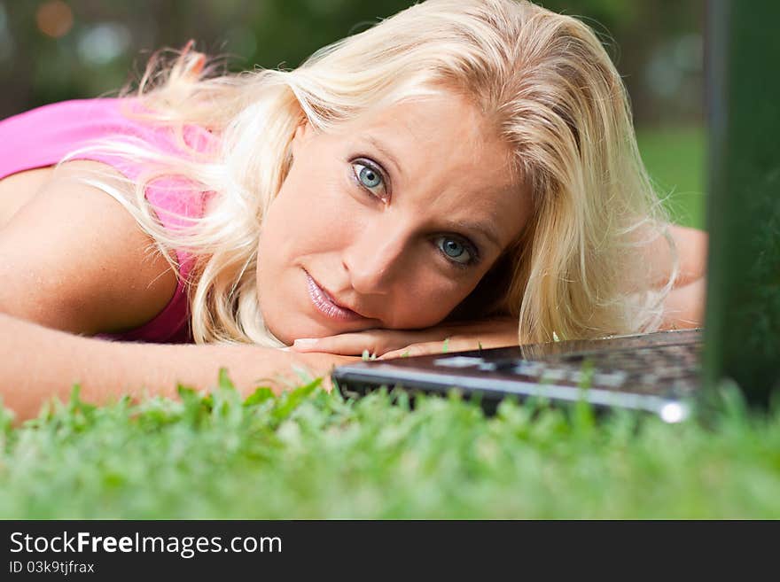 Young attractive woman relax at the park with her laptop