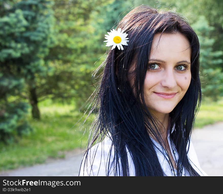 Beautiful smiling woman with flower in hair