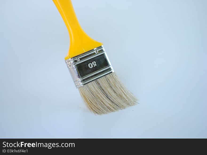 Yellow paint brush works without color isolated on background