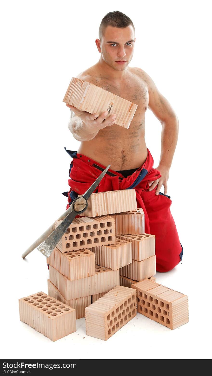 Handsome young worker with a pickaxe and bricks. Handsome young worker with a pickaxe and bricks