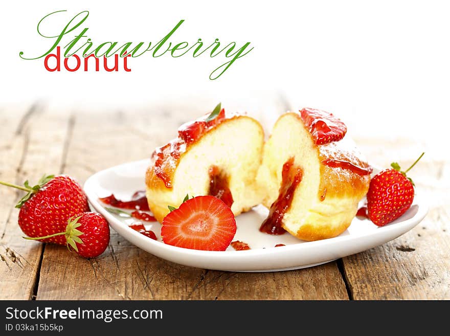 Donut with strawberry jam filling on a plate with place for your text on the left. Donut with strawberry jam filling on a plate with place for your text on the left