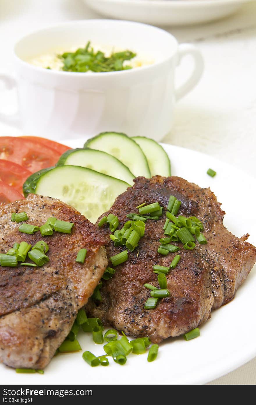 Grilled steak with fresh vegetables in white plate and sauce