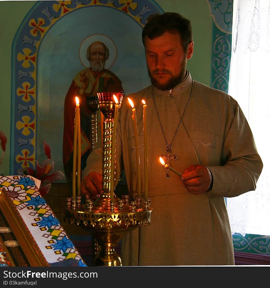 Orthodox priest lights a candle in the church. Orthodox priest lights a candle in the church