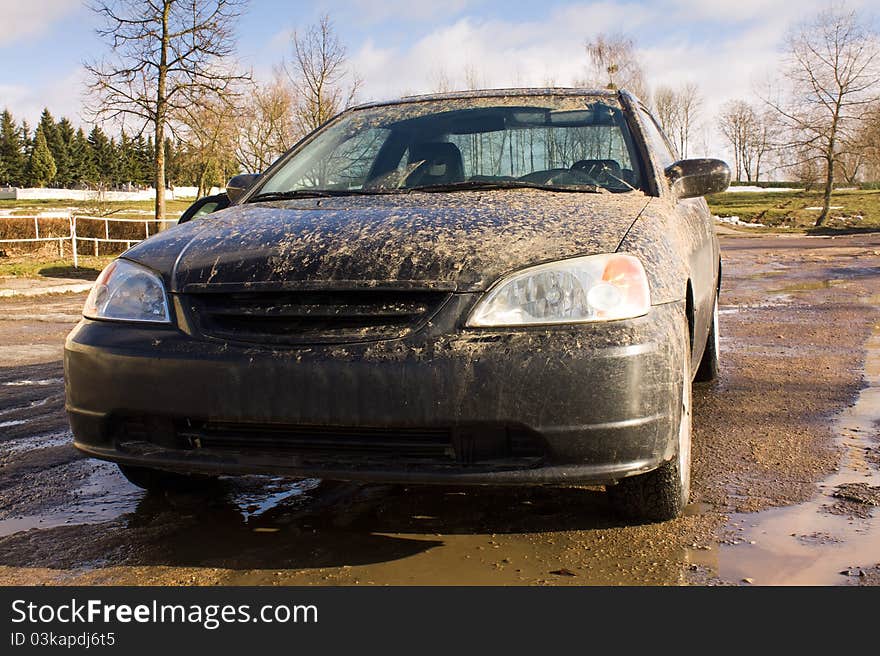 The car smeared in a dirt because of bad roads. The car smeared in a dirt because of bad roads