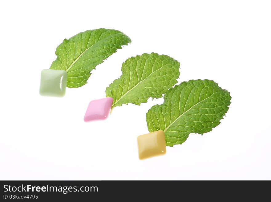 Mint leaf and chewing gum on white background