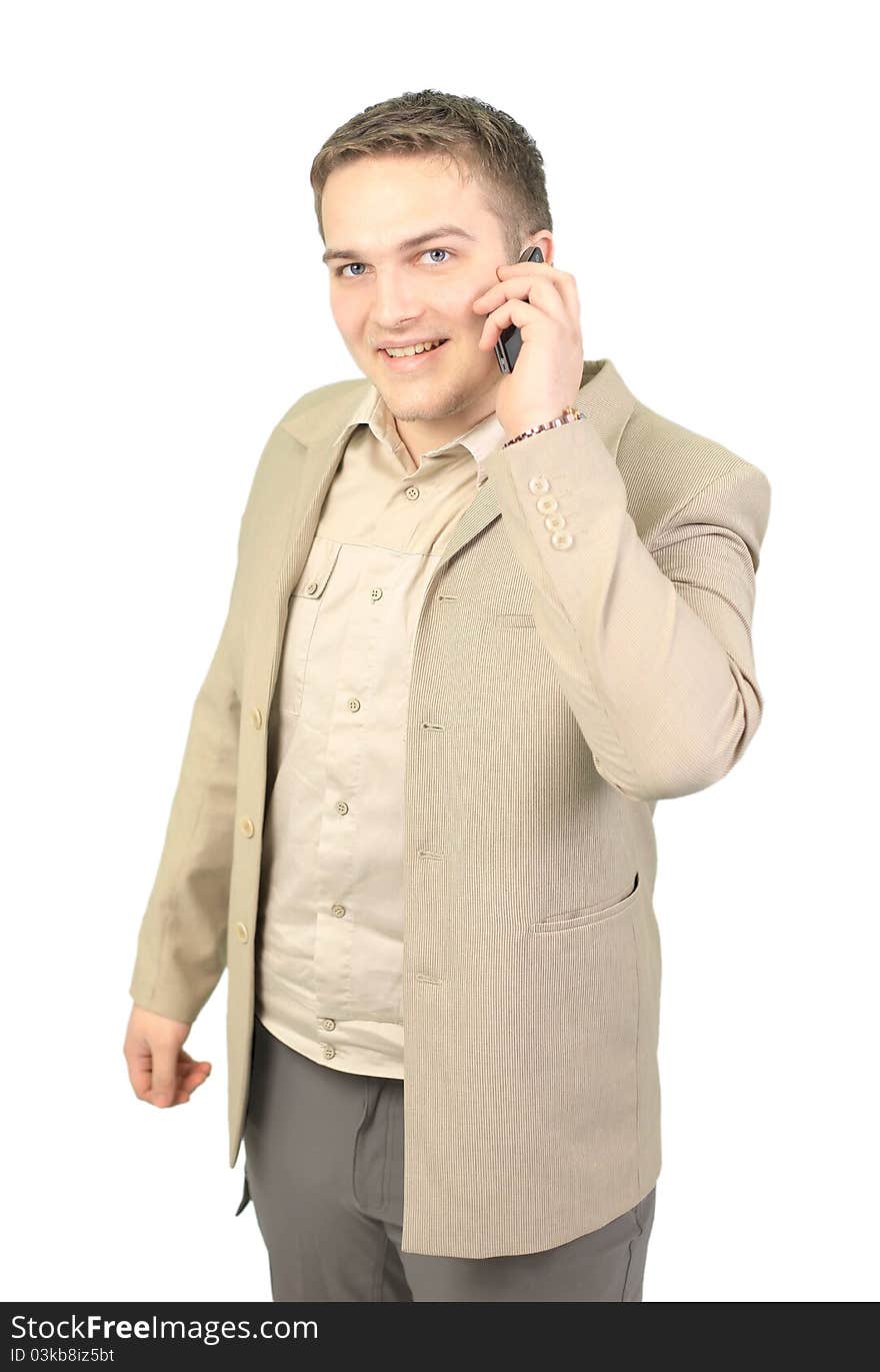 Young smiling businessman calling on phone at office