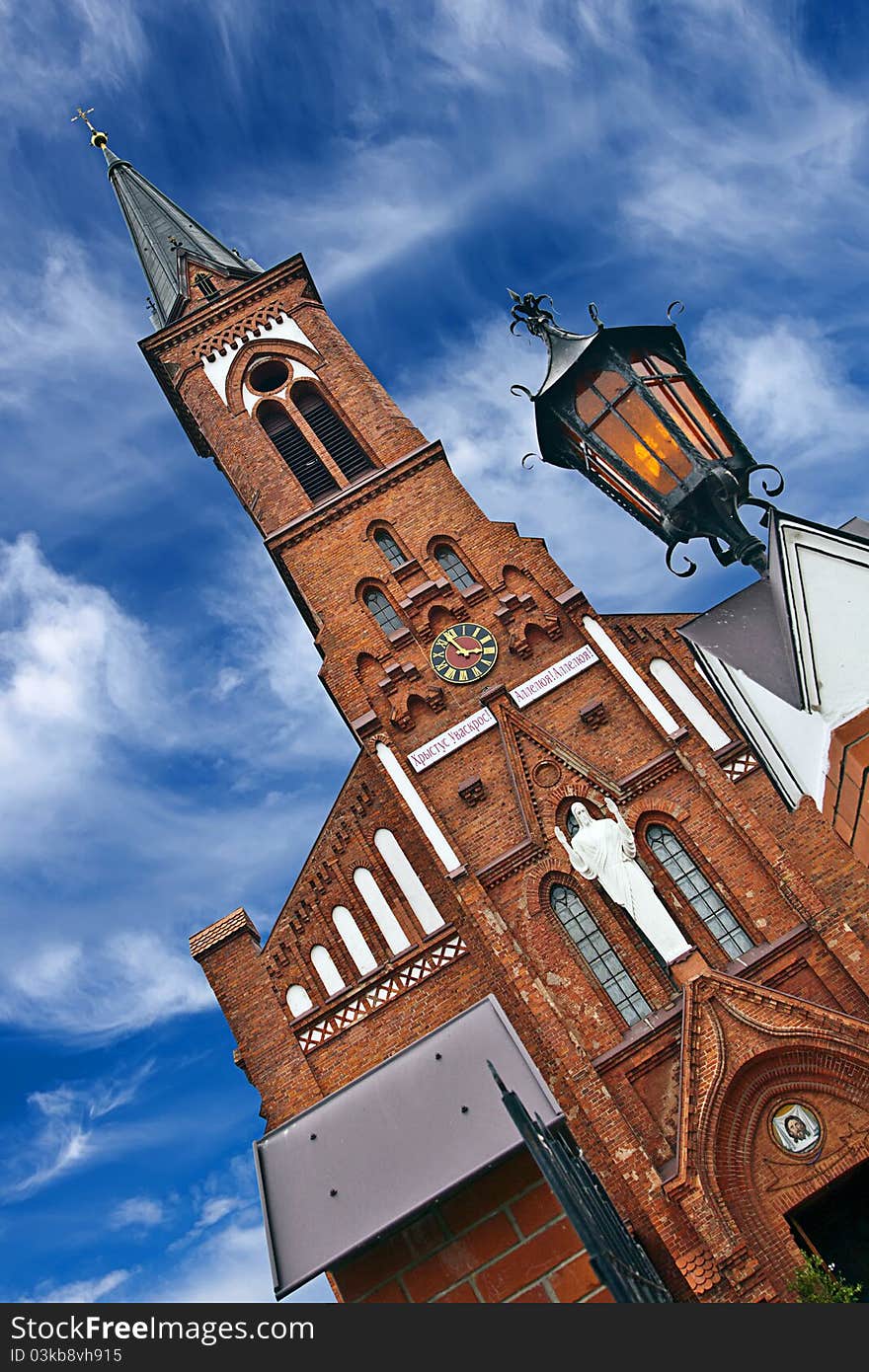 Red church against blue sky.Belarus.