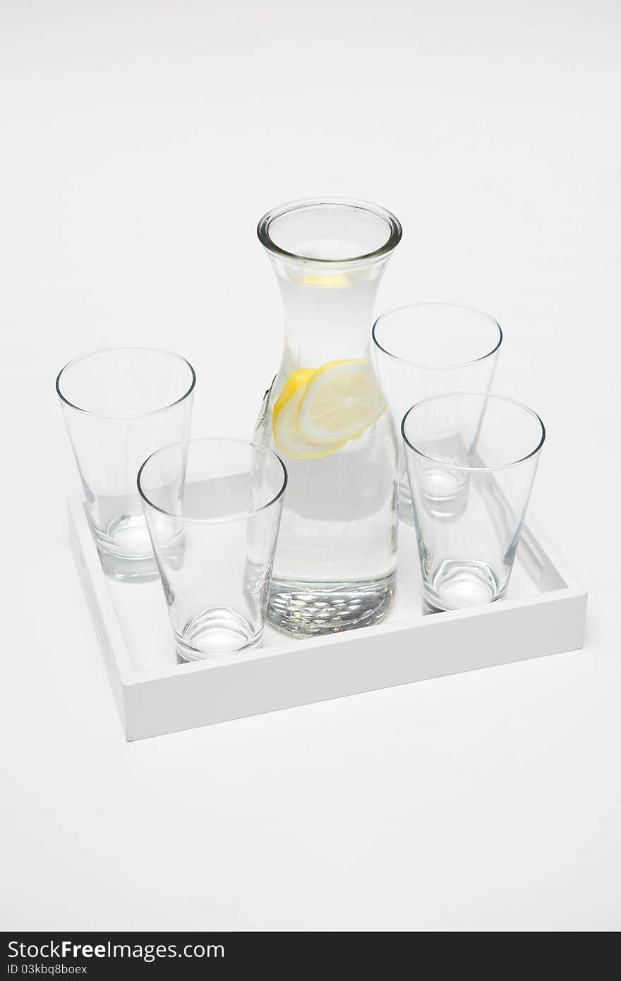 Carafe Of Lemon Water And Four Glasses.