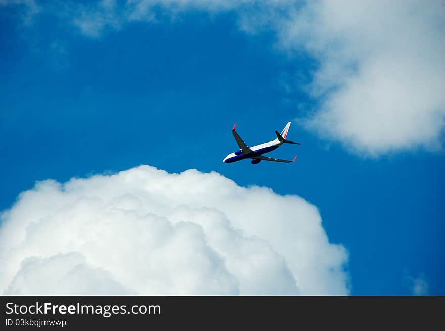 Jet aircraft in a cloudy blue sky