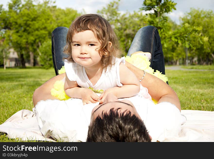 The father holds the cheerful daughter in his arms