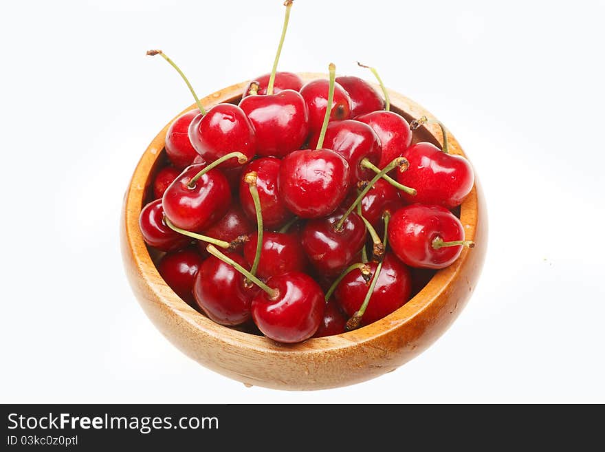 Fresh cherry in the wooden bowl. (Isolated on white)